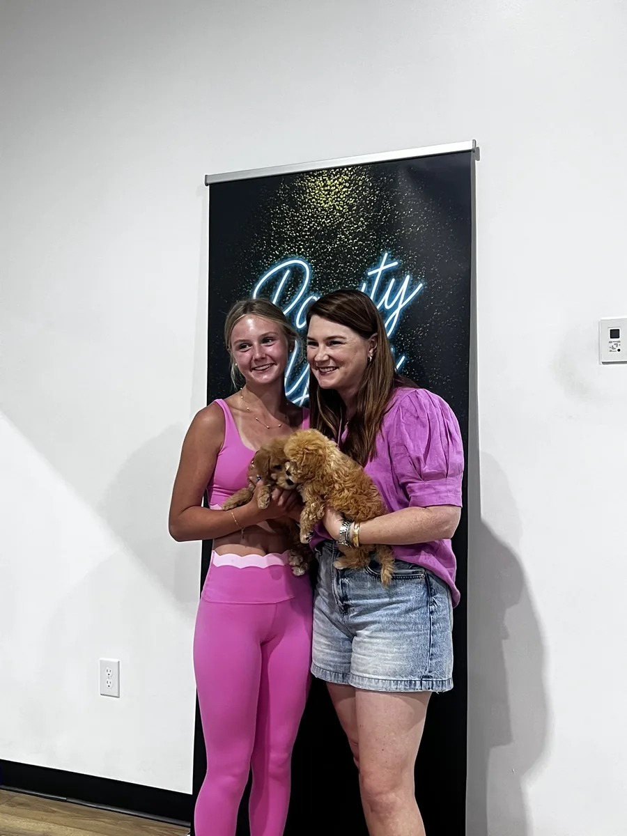 Guests holding a puppy at a mobile Houston puppy yoga party