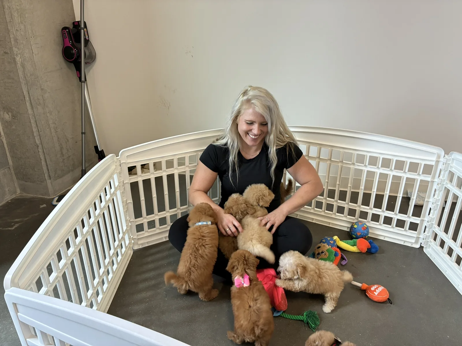 A Pawty Yoga handler sitting in the puppy rest pen with the litter between rotations